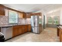 Kitchen with wooden cabinets, stainless steel appliances, mosaic tile backsplash and tile floors at 4648 Rifle Range Rd, Conover, NC 28613
