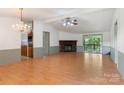 Open living room with a stone fireplace, light-colored hardwood floors and a sliding door to the rear deck at 4648 Rifle Range Rd, Conover, NC 28613