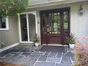 Inviting front entrance with a stone porch, a dark wood door with sidelights and decorative plants at 5153 Glenwood St, Sherrills Ford, NC 28673