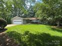 Charming single-story home with a well-maintained lawn and attached garage, nestled in a wooded landscape at 5153 Glenwood St, Sherrills Ford, NC 28673