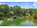Scenic lake view featuring a boat dock with lifts, lush trees, and a serene waterfront homes at 5153 Glenwood St, Sherrills Ford, NC 28673