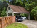 Detached two-car carport, adjacent to a brick wall at 607 Coulwood Dr, Charlotte, NC 28214