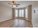 Bright bedroom featuring three windows with wooden floors and a ceiling fan at 623 Olmsted Park Pl # D, Charlotte, NC 28203