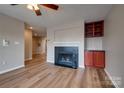 Spacious living room with a cozy fireplace, built-in shelving, and hardwood floors at 623 Olmsted Park Pl # D, Charlotte, NC 28203