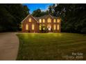 Charming two-story brick home with a well-lit facade and expansive lawn, providing a warm and inviting atmosphere at 763 Evans Manor Dr, Weddington, NC 28104