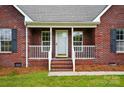 Close up of the brick facade and cozy front porch with painted white railing at 924 Secrest Hill Dr, Monroe, NC 28110