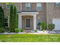 Inviting front entrance with a covered porch, lush landscaping, and a well-maintained lawn at 10044 Markus Dr, Mint Hill, NC 28227