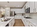 Modern kitchen with stainless steel appliances, white cabinets, and marble countertops at 10044 Markus Dr, Mint Hill, NC 28227