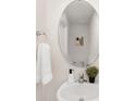 Cozy powder room showcasing a pedestal sink, round mirror, and decorative accents at 1039 20Th Avenue Se Loop, Hickory, NC 28602