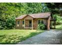 Cozy brick home featuring a covered porch, manicured lawn, and convenient side entrance with a concrete driveway at 110 Book Ct, Statesville, NC 28677