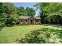 Quaint single-story brick house surrounded by lush greenery, offering a peaceful and private setting at 110 Book Ct, Statesville, NC 28677