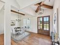 Bright dining room with wood floors, exposed beams, statement lighting, and a view of the landscaped yard at 1172 Springlake Rd, York, SC 29745