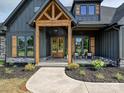 Inviting entryway with natural wood door, rocking chairs on the porch, and landscaped garden beds at 1172 Springlake Rd, York, SC 29745