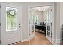 Bright home office with French doors, hardwood floors, and a large desk with modern decor at 13025 Cinnamon Fern Ln, Charlotte, NC 28227