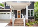 Inviting front porch with brick steps and white railing, leading to a wood door at 1620 Arnold Dr, Charlotte, NC 28205