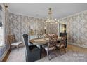 Formal dining room with elegant chandelier, wallpaper, and seating for six at 1625 Bibury Ln, Charlotte, NC 28211