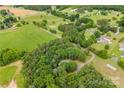 Scenic aerial view of a property featuring a mix of wooded areas and grassy fields at 16453 Nc Hwy 73 Hwy, Albemarle, NC 28001