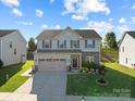 Charming two-story home featuring a well-maintained lawn, stone accents, and a spacious three-car garage at 1725 Mill Creek Sw Ln, Concord, NC 28025