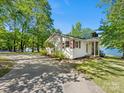 Charming single-story home with stone chimney, brown shutters, and view of the lake at 17835 Terryglass Ln, Charlotte, NC 28278