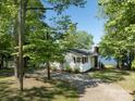 Side view of a quaint home nestled among trees with a view of the lake and a long driveway at 17835 Terryglass Ln, Charlotte, NC 28278