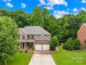 Beautiful two-story brick home with manicured lawn, mature trees, and a convenient two-car garage at 200 Winter Flake Dr, Statesville, NC 28677