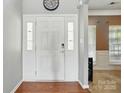 Welcoming entryway features a classic white door with sidelights and beautiful hardwood floors at 2324 Oakdale Creek Ln, Charlotte, NC 28216