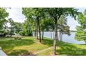 Beautiful green backyard with a walking path leading to the calm waters of the lake at 302 Northwest Dr, Davidson, NC 28036