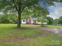 Traditional home with a brick accent, surrounded by mature trees, offering a serene and spacious outdoor area at 4636 Brown Creek Church Rd, Wadesboro, NC 28170