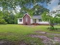 Inviting home featuring a brick facade, complemented by a well-kept lawn and mature landscaping at 4636 Brown Creek Church Rd, Wadesboro, NC 28170