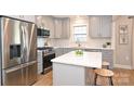 Modern kitchen featuring stainless steel appliances, light grey cabinets, quartz countertops, and a cozy island at 532 Scaleybark Rd, Charlotte, NC 28209