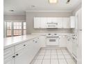 Bright kitchen with white cabinetry, appliances, and tiled floors at 8969 Meadow Vista Rd, Charlotte, NC 28213