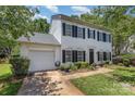 Two-story home with white siding, black shutters, attached garage, and a neatly landscaped lawn for a move-in ready appeal at 9107 Royal Highlands Ct, Charlotte, NC 28277