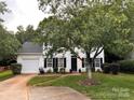 Traditional two-story home with black shutters, a lush front lawn and mature shade tree creating curb appeal at 9107 Royal Highlands Ct, Charlotte, NC 28277