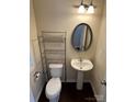 Cozy half-bathroom with pedestal sink, oval mirror, and wood look flooring at 9593 Camberley Nw Ave, Concord, NC 28027