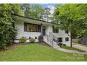 Inviting two-story white brick home with black trim, a well-maintained yard, and a cozy entrance at 1021 Nancy Dr, Charlotte, NC 28211