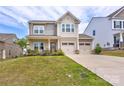 Charming two-story home featuring a two-car garage, covered porch and a well-manicured lawn at 1077 River Haven Sw Ave, Concord, NC 28025