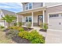 Charming front porch with stone accents, seating, and well-maintained landscaping at 1077 River Haven Sw Ave, Concord, NC 28025