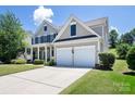 Traditional home with a two-car garage, covered front porch, and meticulous landscaping on a sunny day at 10792 Elsfield Nw Ave, Concord, NC 28027