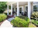 Inviting front porch featuring a porch swing, rocking chairs, and decorative plants enhancing the entrance appeal at 10792 Elsfield Nw Ave, Concord, NC 28027