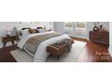 Cozy main bedroom featuring hardwood floors, neutral tones, and ample natural light from balcony access at 1315 East Blvd # 611, Charlotte, NC 28203