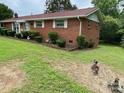 Quaint brick home showcasing mature landscaping, adding natural beauty at 13427 Homewood Dr, Charlotte, NC 28262