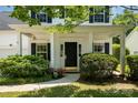 Welcoming front porch with manicured landscaping, covered entrance, and black door with gold hardware at 16121 Wrights Ferry Rd, Charlotte, NC 28278
