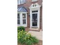 Inviting front entrance with a decorative white door frame, brick facade, and vibrant yellow flowers at 1647 Backcreek Ln, Gastonia, NC 28054