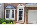 Close-up of an elegantly framed front door with detailed trim and sidelights, set in a brick facade at 1647 Backcreek Ln, Gastonia, NC 28054