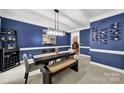Elegant dining room with bold blue walls, white trim, modern lighting, and a wine rack at 16714 Hammock Creek Pl, Charlotte, NC 28278