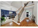 Grand foyer featuring hardwood floors, a staircase with wrought iron spindles, and a view of the dining room at 16714 Hammock Creek Pl, Charlotte, NC 28278