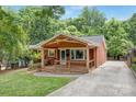 Inviting single story brick home with a well-maintained lawn and covered front porch at 1734 Seifert Cir, Charlotte, NC 28205