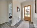 Entryway features beautiful wainscoting, stylish flooring, and a glass-paneled front door at 18013 Grey Mossrun Dr, Charlotte, NC 28278