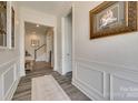 Hallway featuring elegant wainscoting, stylish flooring, and an art-lined walkway at 18013 Grey Mossrun Dr, Charlotte, NC 28278