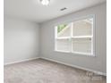 Bright and airy bedroom with plush carpeting and a large window with blinds at 2236 Prairie Rd, Concord, NC 28027